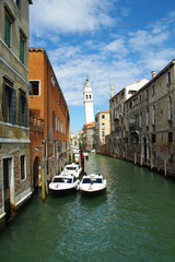 Rio de St. Lorenzo and the slant tower of the Greek Church of St. George. Tree boats are on the green water of the canal