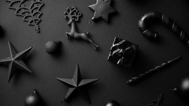 Christmas minimalistic and simple composition in mat black color. Christmas gifts, decorations on black background. Flat lay, top view .
