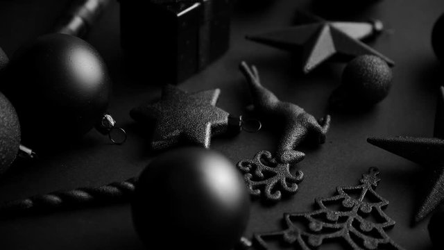 Christmas minimalistic and simple composition in mat black color. Christmas gifts, decorations on black background. Flat lay, top view .