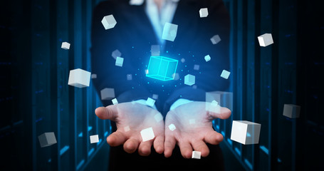 Person holding hologram projection displaying white cubes in server room
