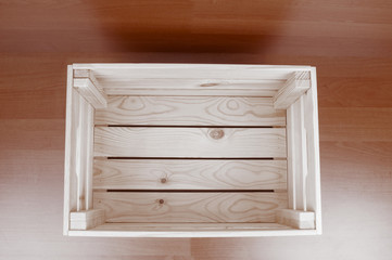 Top view on empty wooden crate on brown floor background