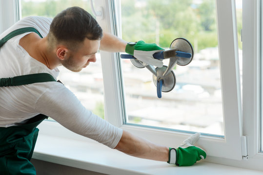Young worker is repairing window