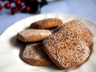 Galletas de canela en primer plano con adorno navideño al fondo