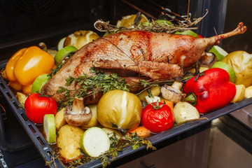 Whole roasted stuffed goose with apples, herbs and vegetables