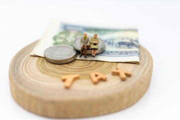 Miniature people, Old couple figure sitting on top of stack coins using as background retirement planning, Life insurance concept.