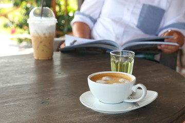 Unhealthy lifestyle of overweight lady drinking cold coffee while reading magazine in the cafe