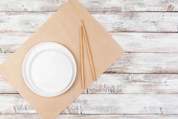 empty white dishes (plate, bowl) on a white wooden background (table), top view, copy space, mock-up