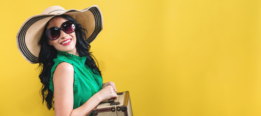 Young woman with a suitcase travel theme on a yellow background