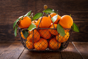 Fresh mandarin oranges fruit or tangerines with leaves in a basket