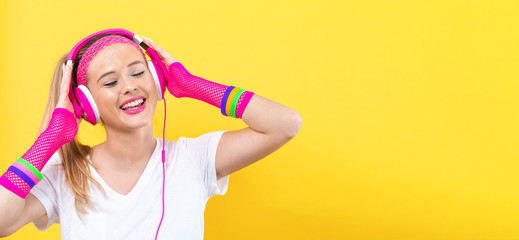 Woman in 1980's fashion with headphones on a yellow background