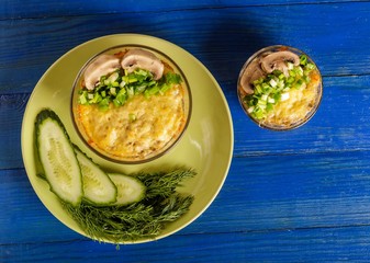 A portion of julienne with cucumbers and dill on a blue table.