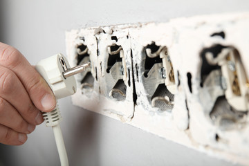 Electrical short circuit, dangerous use of electricity. Damaged socket in the wall.