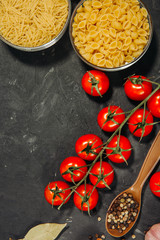 Ingredients with dried Italian pasta, spoon, tomatoes and spices