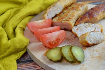Delicious sausages grilled and vegetables on wooden background.