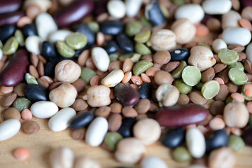 Mix of different beans on wooden background close up