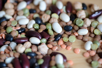 Mix of different beans on wooden background close up