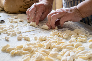 Hands of Italian woman making traditional fresh pasta on a marble table - 236614257