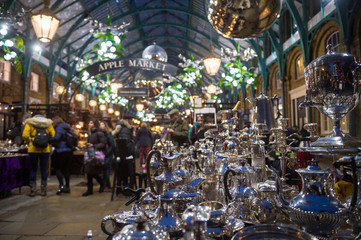 Antiques and collectibles under the holiday lights decorating the neoclassical arches of the Apple...