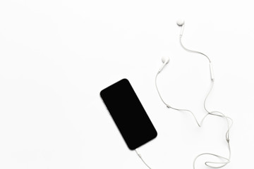 Mobile phone with white earphones isolated on white