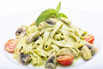 Pasta with mushrooms and tomato  in pesto sauce.
