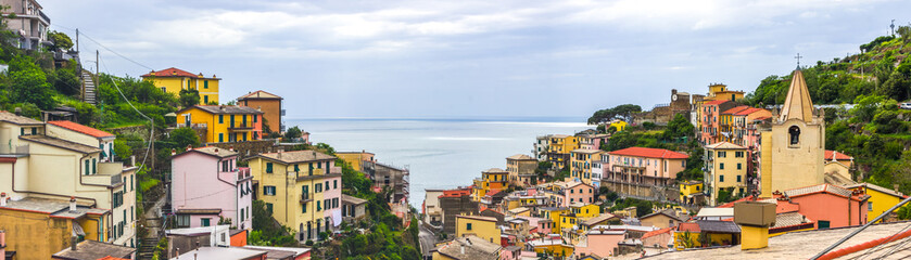Naklejka premium beach streets and colorful houses on the hill in Riomaggiore in Cinque Terre in Italy 
