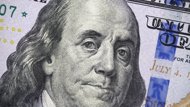 Benjamin Franklin face on new US 100 dollar bill 2013 rotating, money close up. 4K ultra hd video clip