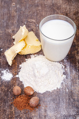 Ingredients for preparing white bechamel sauce on wooden table. Close up