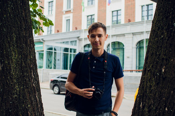 Man hanging film camera on neck at walking street and travel concepts.