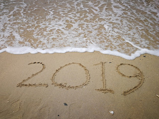 2019 written on sandy beach