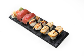 Zestaw sushi. Kawałki sushi nigiri  na kamiennym czarnym talerzu