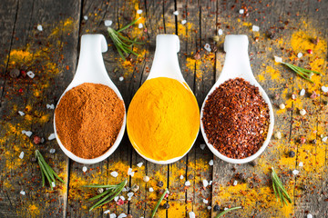 Spices in Wooden spoon. Herbs. Curry, Saffron, turmeric, rosemary, cinnamon, garlic, pepper, anise on wooden rustic background. Collection of spices and herbs. Salt, paprika. 