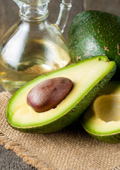 Close-up of an avocado and avocado oil on wooden table. Healthy food concept.