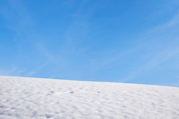 Schneefeld und blauer Himmel mit Freifläche - winterlicher Hintergrund