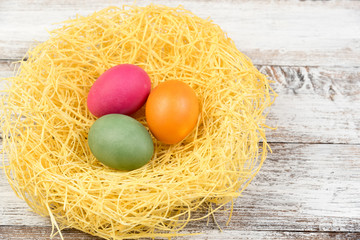 Fototapeta na wymiar Basket with Easter eggs on white wooden background