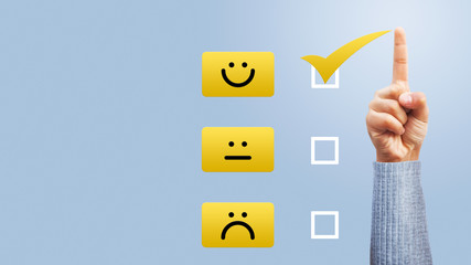 Hand of client show a feedback with smiley face card. Service rating, satisfaction concept