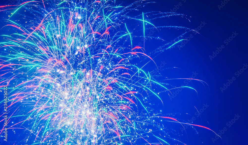 Poster brightly colorful fireworks on twilight background with copy space