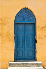 Fototapeta na wymiar Blue Door in a Yellow Building
