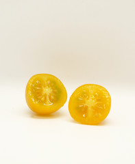 Little yellow tomato on white background