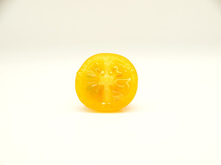 Little yellow tomato on white background