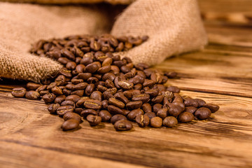 Sackcloth and scattered coffee beans on wooden table