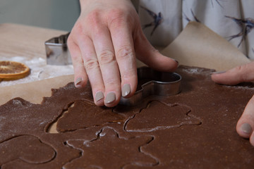 Cutting Christmas cookies, baking gingerbread men, making christmas cookie , homemade traditional  dessert.