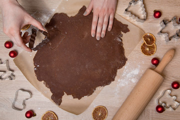 Cutting Christmas cookies, baking gingerbread men, making christmas cookie , homemade traditional  dessert.