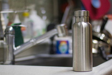 Insulated Stainless Bottle with utensils and sink kitchen background