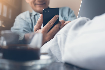 Man using smartphone and laptop computer