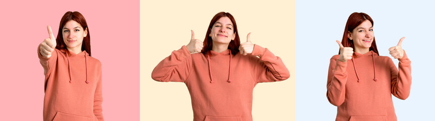 Set of Young redhead girl with pink sweatshirt giving a thumbs up on colorful background