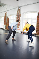 Fototapeta premium Breakdance trainer and her learner training together in front of one another in studio