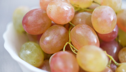 Grapes in a porcelain plate. Ripe pink Muscat grapes.