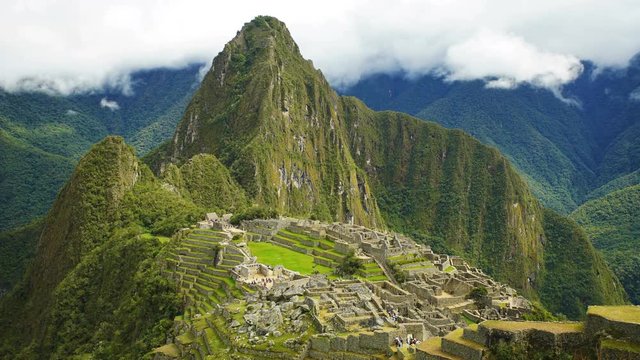 Time lapse view of tourists visiting Machu Picchu an Andean ancient lost city ruins deep in the Rainforest of South America surrounded by Mountain Peaks