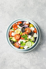 Fototapeta na wymiar Avocado feta Greek salad in a bowl. Top view, space for text.
