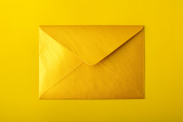 Golden envelope on a yellow background. Mock-up